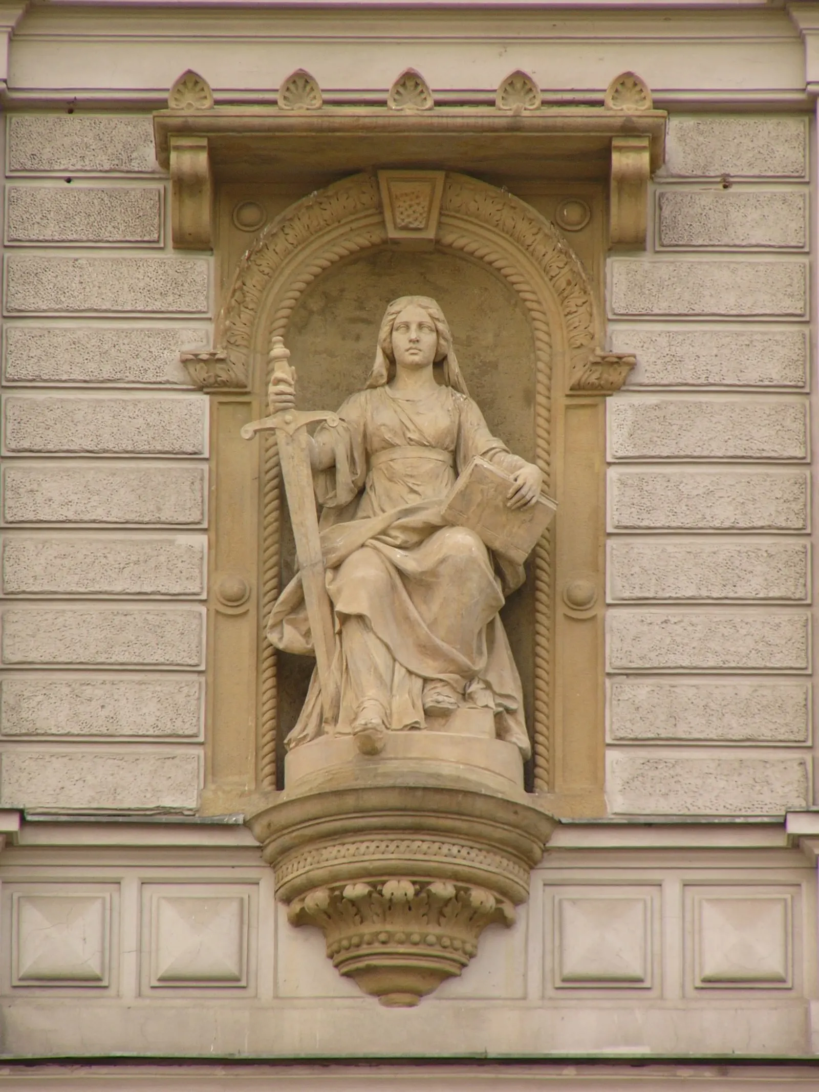 Stone statue of Justice on a building facade